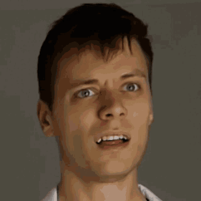 a close up of a man 's face with his mouth open and a surprised look on his face .