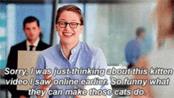 a woman wearing glasses is smiling and talking about a kitten video she saw online .