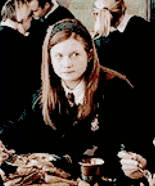 a girl in a school uniform sits at a table