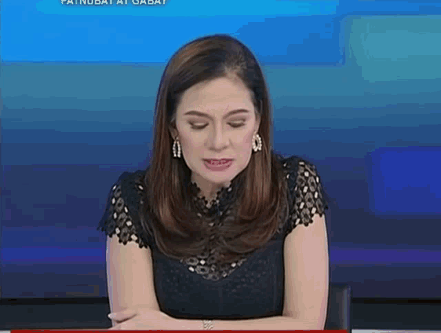 a woman sitting in front of a blue background with the words patnubay at gabay