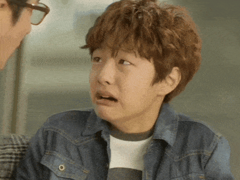 a young boy wearing a denim jacket is making a face