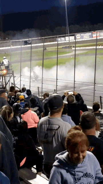 a group of people watching a race with a man wearing a shirt that says 7
