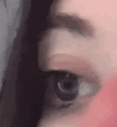 a close up of a woman 's eye with a pink lipstick on her face .