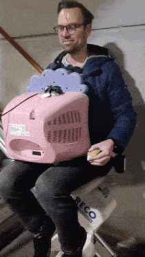 a man in a blue jacket is sitting on a reco exercise bike
