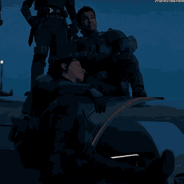 a couple of soldiers sitting on top of a vehicle with the next thing written in the corner