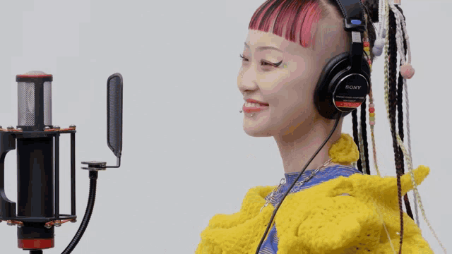 a woman wearing a pair of sony headphones is smiling