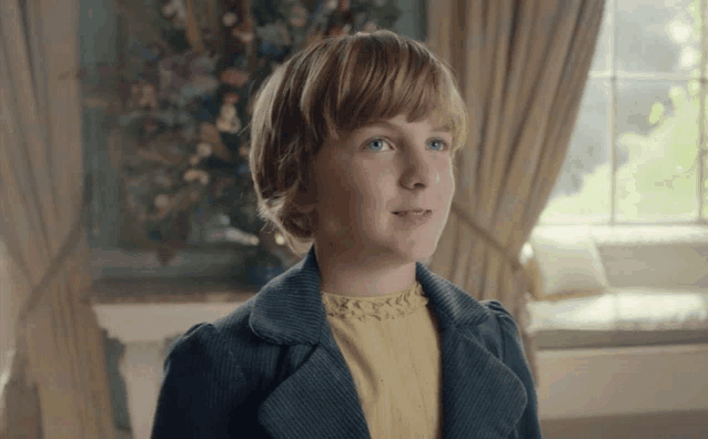a young girl with blonde hair and blue eyes is wearing a yellow dress and a blue jacket
