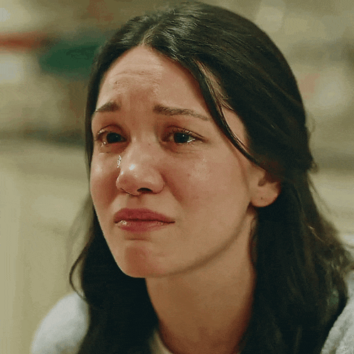 a close up of a woman 's face with tears running down her face