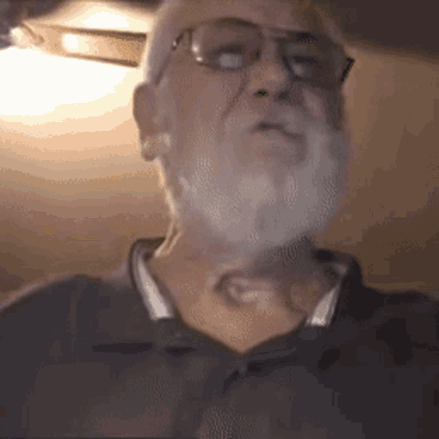an older man with glasses and a beard is looking at the camera