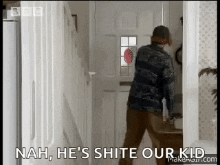 a man is standing in a hallway with the words `` nah , he 's shite our kid '' on the screen .