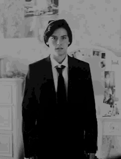 a black and white photo of a man in a suit and tie .