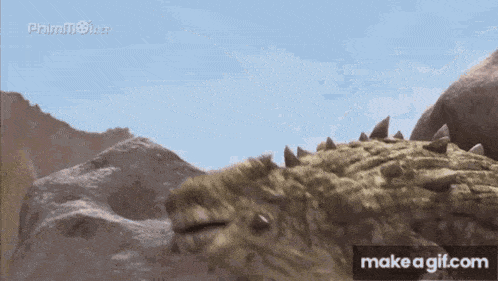a gif of a dinosaur with the words make a gif.com under it
