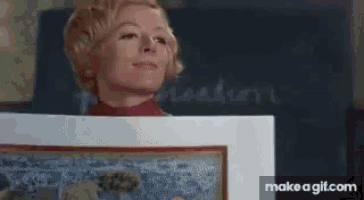 a woman is holding a painting in front of a chalkboard that says pleasure