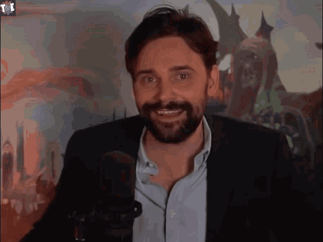 a man with a beard in front of a microphone