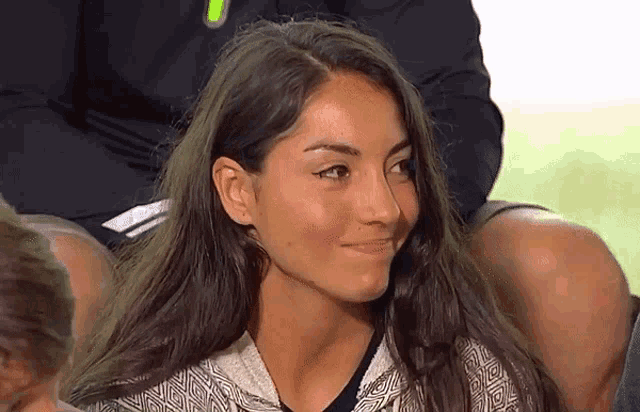 a woman with long hair is smiling and wearing a black shirt
