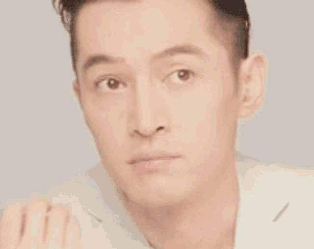 a close up of a man 's face with a blurred background and a serious look on his face .