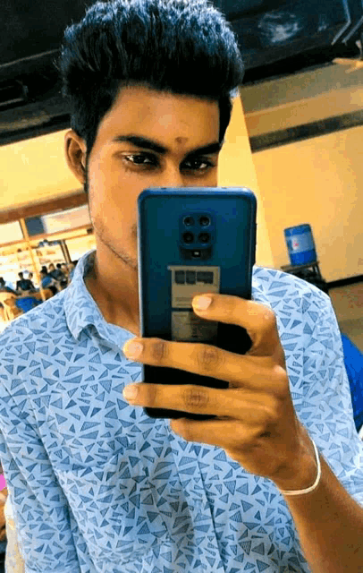 a man taking a picture of himself with a cell phone