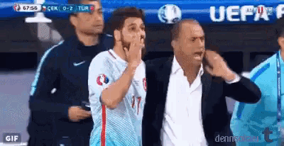 a man in a suit is standing next to a man in a blue shirt with the number 17 on it