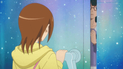 a girl in a yellow hoodie is standing in front of a blue wall