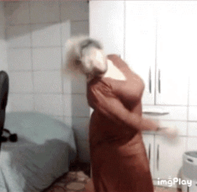 a woman in a red dress is dancing in a room