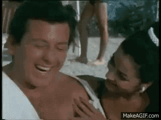 a man and a woman are laughing on the beach .