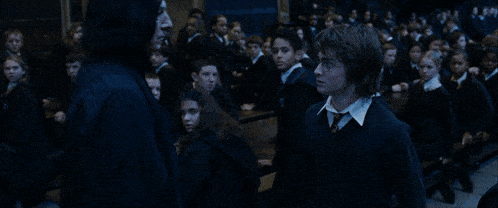 harry potter is standing in front of a large crowd of people