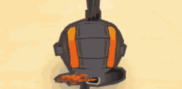 a black and orange robot with a yellow beam coming out of it 's mouth .