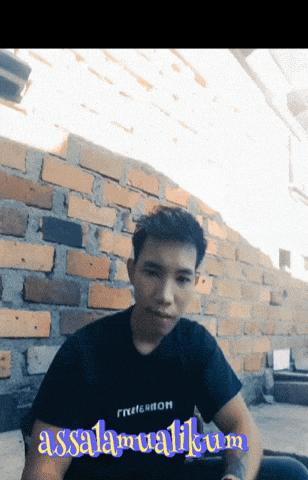 a man wearing a black shirt with the word assalamualaikum on the front