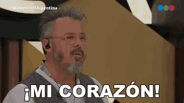 a man with a beard and glasses says mi corazon