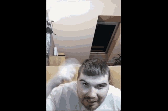 a man with a beard is sitting in a chair and making a face