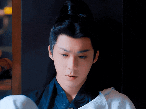 a young man with a ponytail is wearing a blue and white outfit