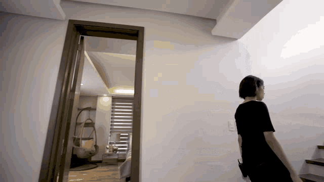 a woman in a black dress walking down stairs