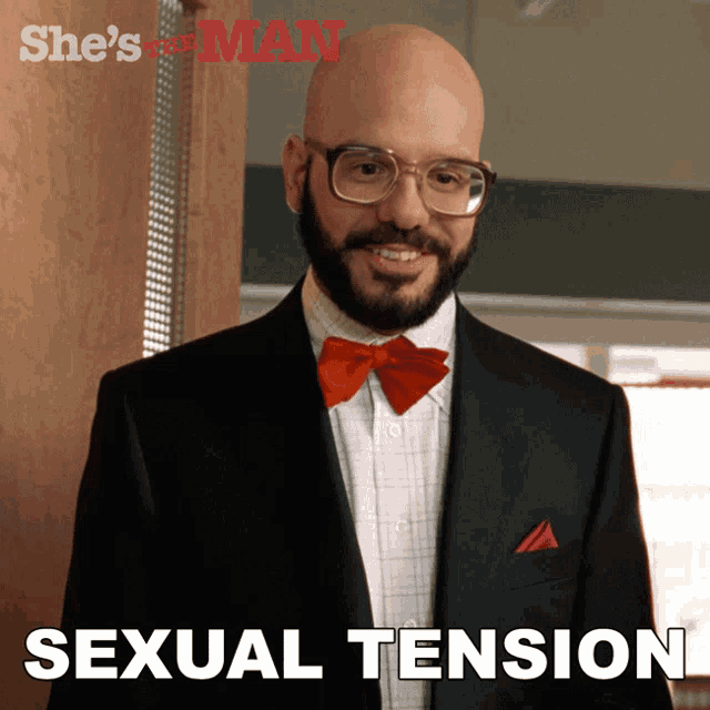 a man wearing glasses and a red bow tie with the word sexual tension written below him