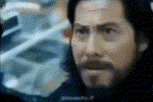 a pixelated image of a man with a beard and a tattoo on his forehead