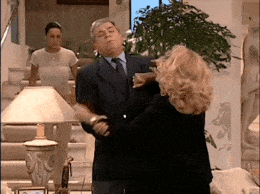 a man in a suit and tie is being attacked by a woman