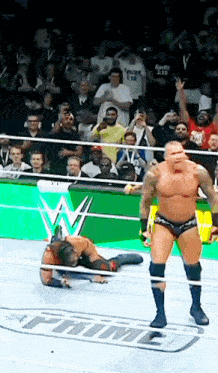 a wrestler is standing in a wrestling ring with the word time in the background