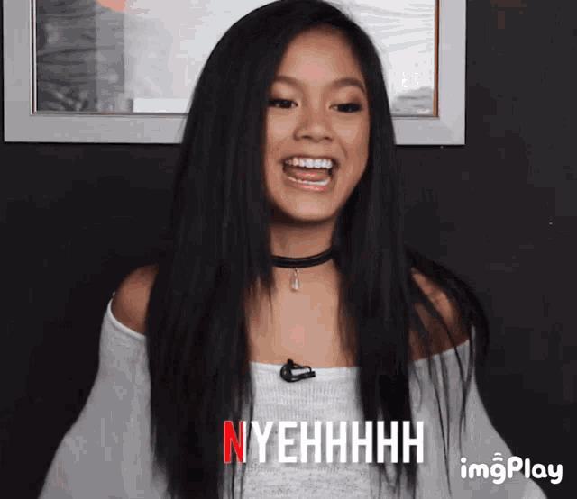a girl with long black hair is laughing and says nyehhhh on the bottom