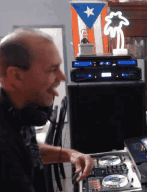 a man wearing headphones is playing music in front of a flag