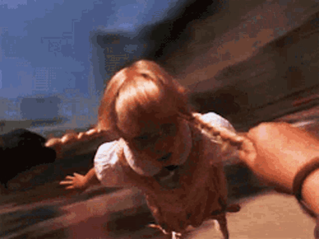 a doll with braids is being held by a person .