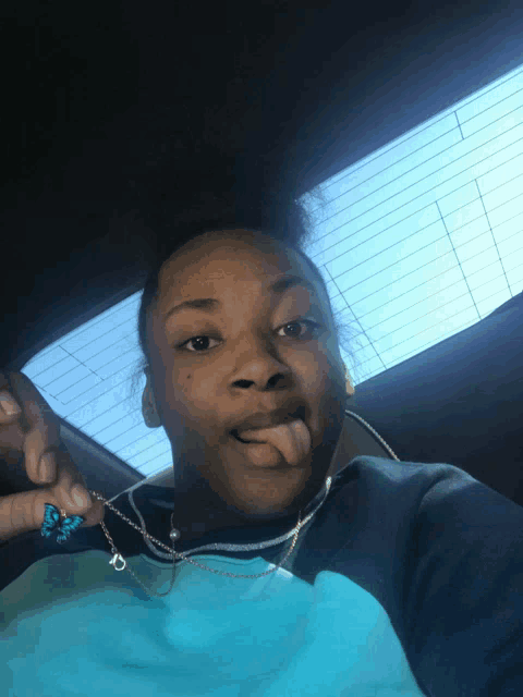 a person wearing a blue shirt that says adidas on it sticks out their tongue