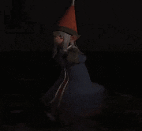 a woman in a witch costume is standing in the dark .