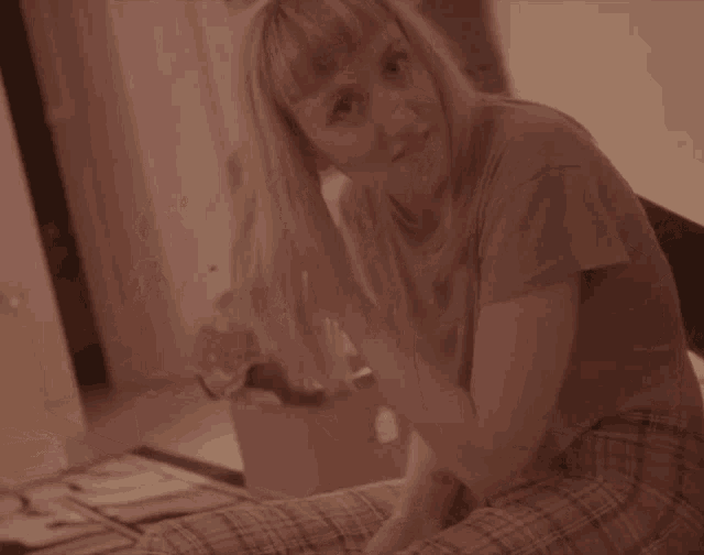 a woman in plaid pants sits on a couch
