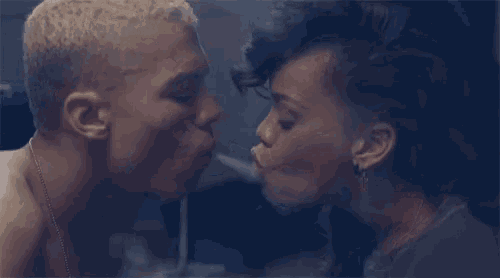 a man and a woman are kissing behind a glass door .
