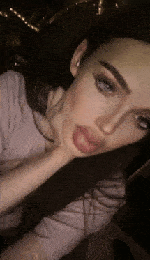 a woman with long dark hair is taking a selfie