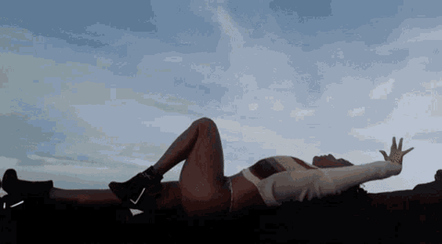 a woman is laying on the ground with her arms outstretched .