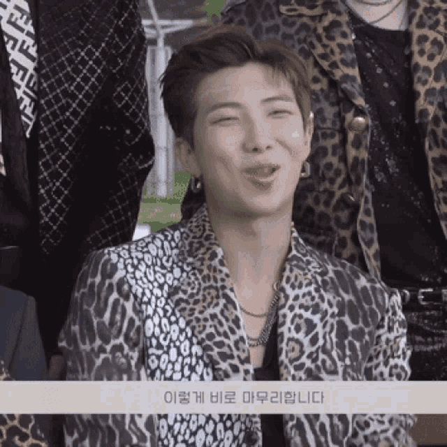 a man in a leopard print jacket is laughing