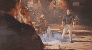 a man in a black shirt and white pants stands in a room