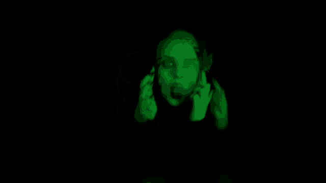 a woman is giving the middle finger in a green background