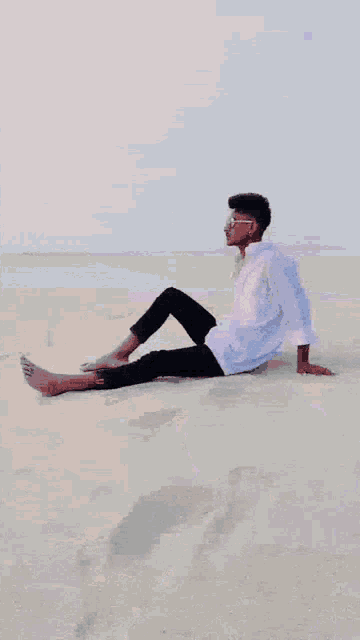 a man in a white shirt is standing on the beach