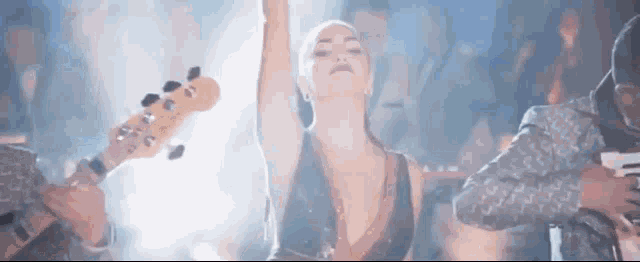 a woman is dancing in front of a band while a man plays a bass guitar .